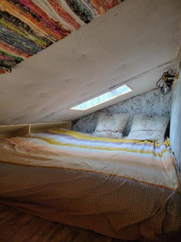 a bed in a room with a window at Tiny House La Chevêchette in Besson