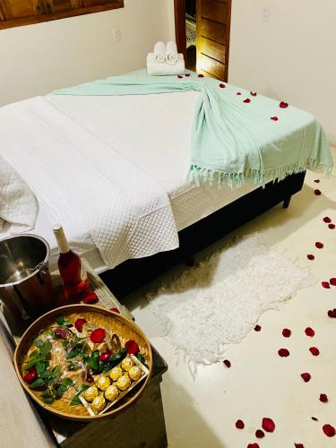 a bedroom with a bed and a bowl of food on the floor at Pousada Amor de Casa in Trancoso