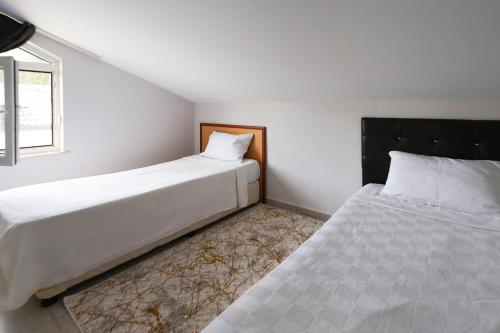 a bedroom with two beds and a window at Mavi Melodi Suite in Fethiye