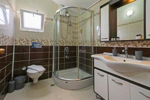a bathroom with a shower and a sink and a toilet at Mavi Melodi Suite in Fethiye