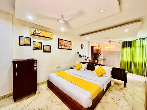 a bedroom with a large bed with yellow and white sheets at Hotel Hauz Khas Inn Near Hauz Khas Fort and Deer Park in New Delhi