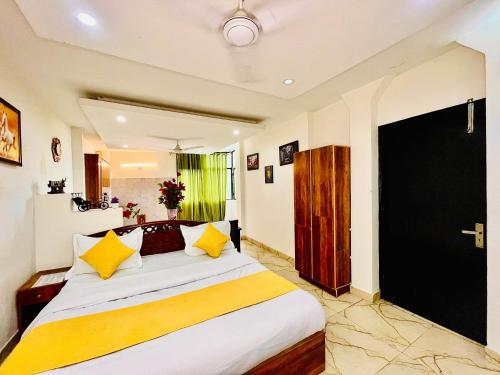 a bedroom with a large white bed with yellow pillows at Hotel Hauz Khas Inn Near Hauz Khas Fort and Deer Park in New Delhi