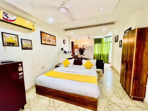 a bedroom with a large bed with yellow pillows at Hotel Hauz Khas Inn Near Hauz Khas Fort and Deer Park in New Delhi