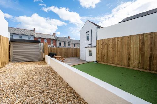 a backyard with a green lawn next to a wooden fence at Brynglas House by Tŷ SA in Newport