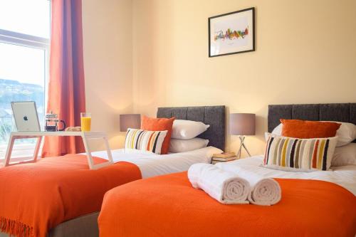 two beds sitting next to each other in a bedroom at Beechwood House by Tŷ SA - ICC & Celtic Manor in Newport