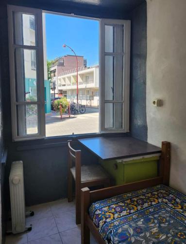 1 dormitorio con ventana, cama y escritorio en Just for sleep - Hoche APT, en Le Pré-Saint-Gervais