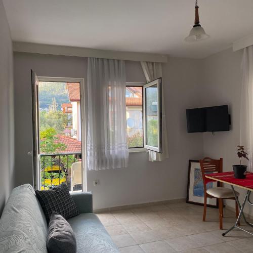 a living room with a couch and a table and windows at Mavi Melodi Suite in Fethiye