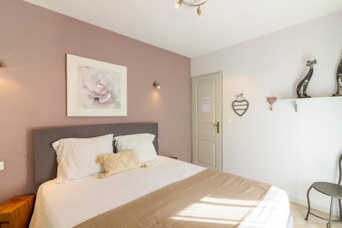 a bedroom with a large bed with white sheets at Chambre d'hotes Les Clauzels in Proissans