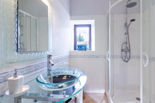 a bathroom with a glass sink and a shower at Chambre d'hotes Les Clauzels in Proissans