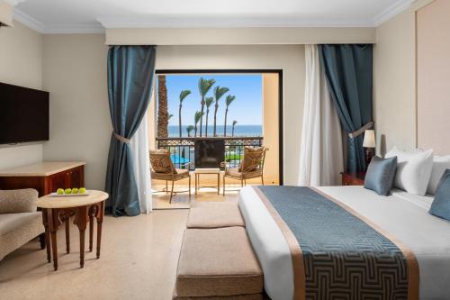 a hotel room with a bed and a view of the ocean at Pickalbatros The Palace Port Ghalib in Port Ghalib