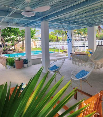 a patio with chairs and a hammock and a pool at Elegant chalet 2 minutes from the beach Ideal families 