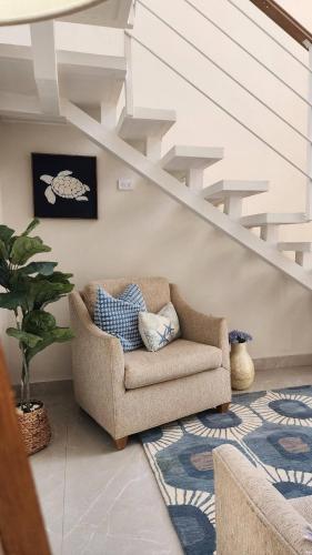 a living room with a couch and stairs at Elegant chalet 2 minutes from the beach Ideal families 