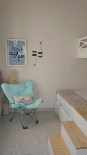 a room with a blue chair and a bed at Elegant chalet 2 minutes from the beach Ideal families 