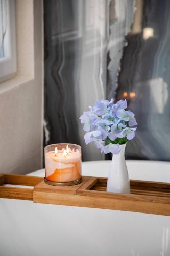 a candle and a vase with a flower on a table at Elegant chalet 2 minutes from the beach Ideal families 