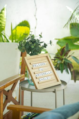a sign sitting on a table with a plant at Elegant chalet 2 minutes from the beach Ideal families 
