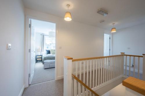 a hallway with a stairway with a room with a chair at Ariel Wharf by Tŷ SA in Newport