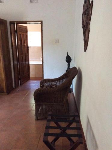 a living room with a chair and a cat on the wall at Tabonina Guesthouse in Livingstone