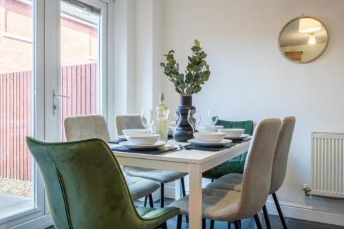 a dining room with a table with chairs and a mirror at Ariel Wharf by Tŷ SA in Newport