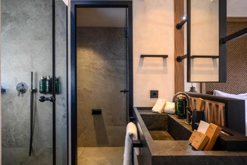 a bathroom with a shower and a sink at Nalu Resort & SPA Adults Only Hotel in Adelianos Kampos