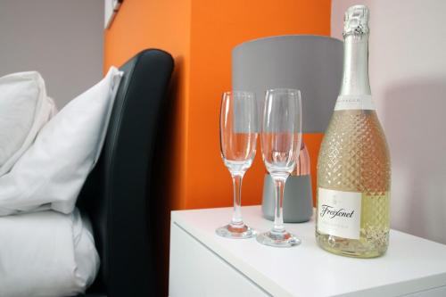a bottle of champagne and two wine glasses on a dresser at Stunning sea views - Barry's Retreat by Tŷ SA in Barry