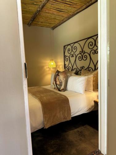 a bedroom with a large bed with a headboard at Dagbreek Cottages in Keimoes
