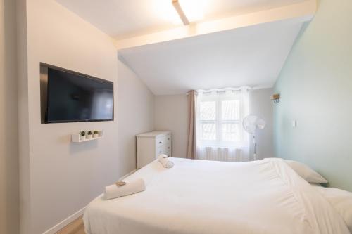 a bedroom with a bed and a flat screen tv at Appart'Hotel Tournusien in Tournus