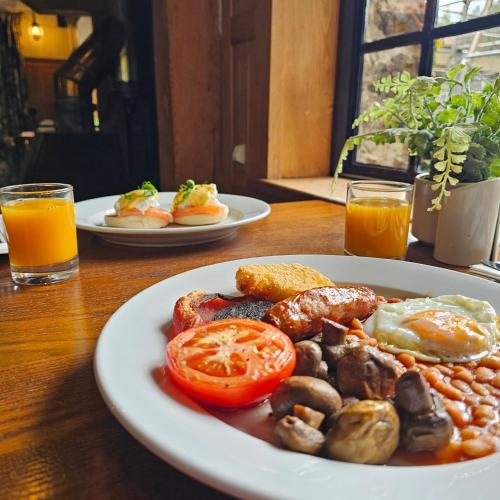 Dos platos de comida de desayuno en una mesa de madera en Lakeview Manor, en Dunkeswell