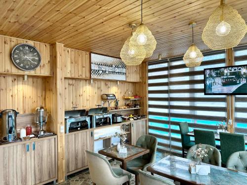 a restaurant with tables and chairs and a clock at Hotel Park in Batumi