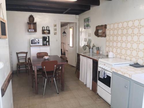 a kitchen with a table and a dining room at Le logis des Fadettes in Saint-Martin-le-Mault