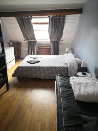 a bedroom with two beds and a window at Le logis des Fadettes in Saint-Martin-le-Mault