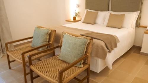 a bedroom with a large bed and two chairs at Ostuni a Mare in Ostuni