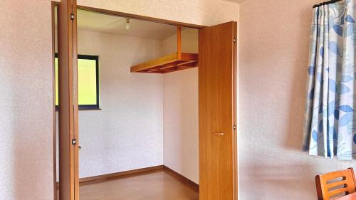 a room with a hallway with a mirror and a shelf at Torinami Fuji View House in Fujinomiya