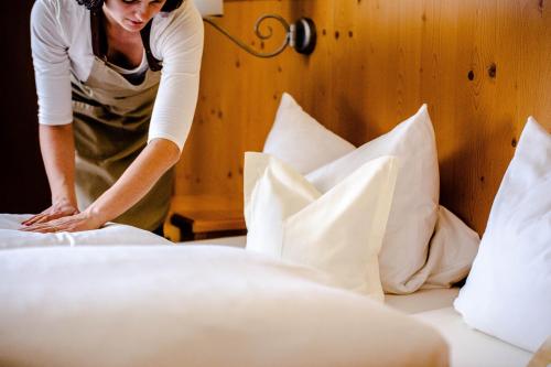 a woman making a bed in a hotel room at Hotel Weyh in Pressath