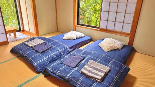 two beds sitting next to each other in a room at Torinami Fuji View House in Fujinomiya