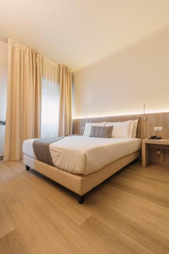 a bedroom with a large bed and a window at Living Hotel Milano in Cornaredo