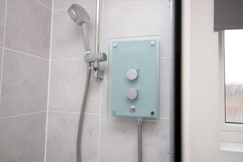 a shower with a shower head in a bathroom at Buxton Way by Tŷ SA - 3 bedroom house in Royal Wootton Bassett