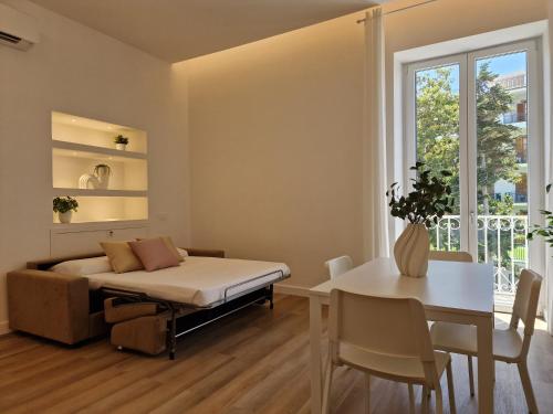 a bedroom with a bed and a table and a window at De Angelis Apartments - GOLD in Sant'Agnello