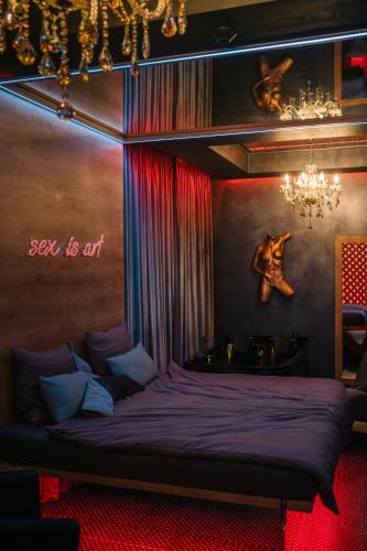 a bedroom with a bed with a sign that says sex is art at Story Rooms in Olomouc
