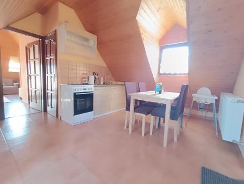 een keuken met een witte tafel en een wit fornuis bij Szóládi Vendégház in Szólád