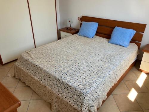 a bedroom with a bed with blue pillows on it at Il Casale di Dorothea in Canino