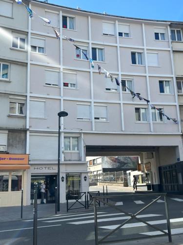 a large white building with flags hanging from it at Le Faidherbe Hotel Coeur de ville in Boulogne-sur-Mer