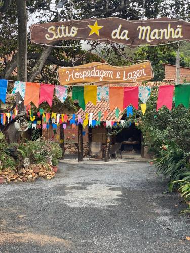 a entrance to a store with colorful flags and a sign at Sítio Estrela da Manhã Hospedagem e Lazer in Palmeiras