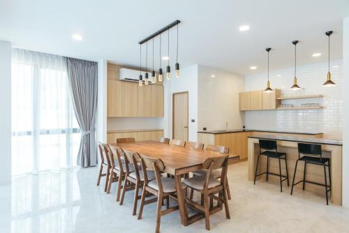 a kitchen and dining room with a wooden table and chairs at Ma-Umi Chiang Mai pool villa 5 BRs - 10 mins to city center and Airport in Chiang Mai