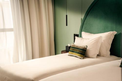 a bedroom with a bed with a green wall at The MN56 Hotel in Lagos
