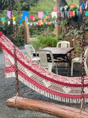 a hammock with a table and chairs and flags at Sítio Estrela da Manhã Hospedagem e Lazer in Palmeiras