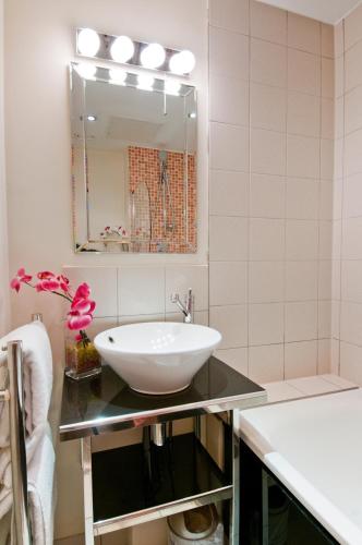 a bathroom with a sink and a mirror at Grand Plaza Serviced Apartments in London