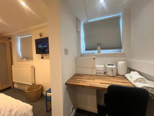 a room with a desk with a bed and a window at The bluebird Bed and Breakfast I in Headingley
