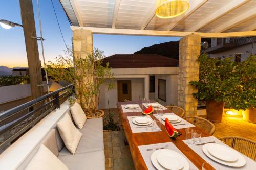 a patio with a table and chairs on a balcony at The Bridge House in Spílion