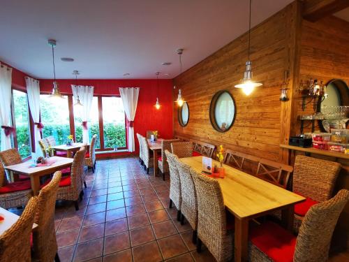 a restaurant with wooden walls and tables and chairs at Penzion Kovářov in Frymburk
