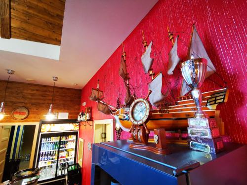 a bar with a clock on a red wall at Penzion Kovářov in Frymburk